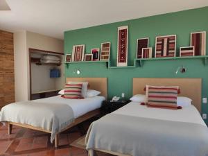 2 camas en una habitación con paredes verdes en Hotel Rosario Lago Titicaca, en Copacabana