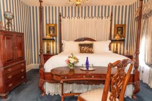 ein Schlafzimmer mit einem Bett und einem Tisch mit Blumen darauf in der Unterkunft Antrim 1844 in Taneytown