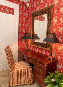 Zimmer mit einem Schreibtisch mit einem Spiegel und einem Stuhl in der Unterkunft Antrim 1844 in Taneytown