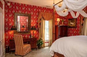 a bedroom with red wallpaper and a bed and a desk at Antrim 1844 in Taneytown