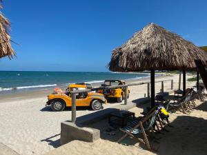 un par de camiones amarillos estacionados en una playa en Blue Ocean Ponta Negra, en Natal