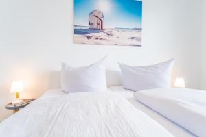 een witte slaapkamer met 2 bedden en een rode schuur bij Ferienwohnung am Kleinbahnhof in Binz