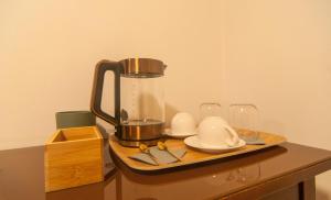 bandeja con cafetera y vasos en una mesa en Umbrian Concierge - Alla Rocca, en Perugia