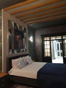a bedroom with a bed and a painting on the wall at Alfa Studio in Sibiu