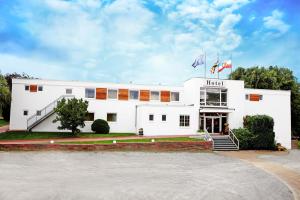 ein weißes Gebäude mit zwei Flaggen davor in der Unterkunft Hotel Oymanns in Hamberge