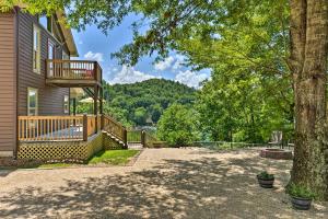 a house with a deck and a tree at Renovated Home with Private Dock on Watauga Lake in Butler
