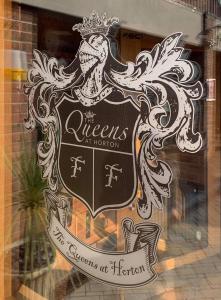 um sinal na janela de uma loja em The Queens At Horton em Telford