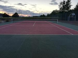 un campo da tennis con una rete sopra di Le camping du capitaine a Maranville