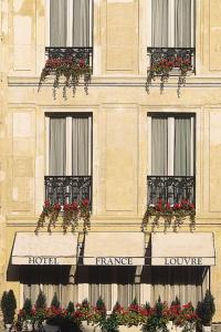a building with flowerpots on the windows of a building at France Louvre in Paris