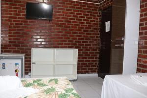 um quarto com uma cama e uma parede de tijolos em Pousada Potiguar em Porto de Galinhas