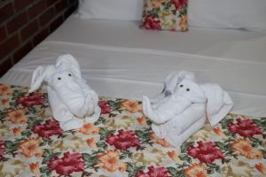 two stuffed elephants sitting on top of a bed at Pousada Málaga in Porto De Galinhas