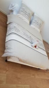 a white bed with white pillows on top of it at Maison Neuve Moderne in Fresney-le-Vieux