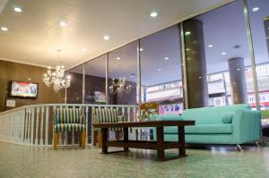 eine Lobby mit einem Sofa, einem Tisch und Stühlen in der Unterkunft Esmeralda Palace Hotel in Buenos Aires