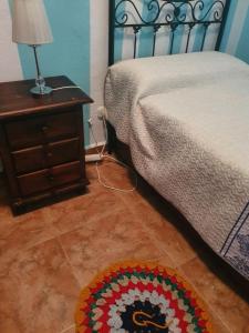 a bedroom with a bed and a table with a lamp at Casa mari carmen in Almuñécar