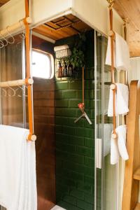 a bathroom with green tiles and a shower with towels at Abbeyfield Horsebox Glamping in Morpeth