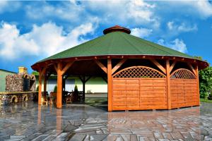 a gazebo with a green roof on a patio at Dworek Zacisze in Września