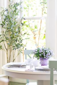 einen Tisch mit Platten und eine Vase Blumen darauf in der Unterkunft Garden Street Inn Downtown San Luis Obispo, A Kirkwood Collection Hotel in San Luis Obispo