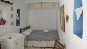 a small bedroom with a bed and a dresser at Traditional Renovated House in the Centre of Anafi in Anafi