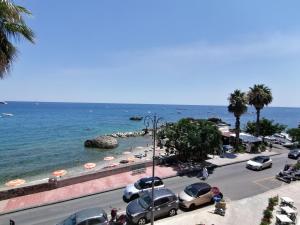 a beach with cars parked next to the water at Lucia & Giovanni in Giardini Naxos