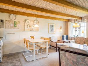 a living room with a table and chairs and a clock at 4 person holiday home in Nørre Nebel in Nørre Nebel