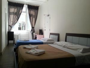 a bedroom with two beds with towels on them at Central Private Hotel in Sydney