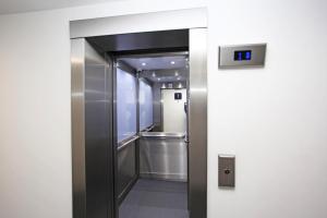 een lift in een gebouw met een klok aan de muur bij Broad Gauge Apartments in Wolverhampton