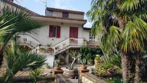 a house with red shutters and palm trees at B&B il giardino di Eolo in Pietramelara