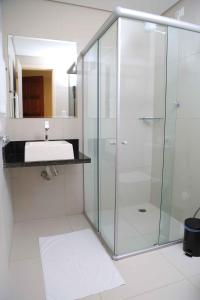 a bathroom with a glass shower and a sink at Pousada Elo Inn in Recife
