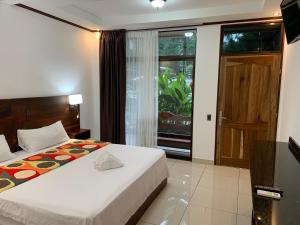 a hotel room with a bed and a window at Hotel Manuel Antonio Park in Manuel Antonio