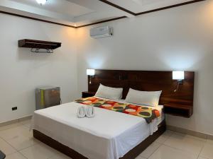 a bedroom with a large bed with two shoes on it at Hotel Manuel Antonio Park in Manuel Antonio
