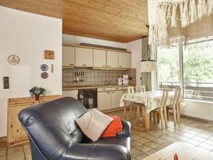 eine Küche und ein Esszimmer mit einem Sofa und einem Tisch in der Unterkunft Snug Apartment in St Andreasberg in Harz in Sankt Andreasberg