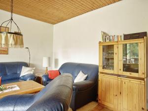 ein Wohnzimmer mit einem blauen Sofa und einem Tisch in der Unterkunft Snug Apartment in St Andreasberg in Harz in Sankt Andreasberg