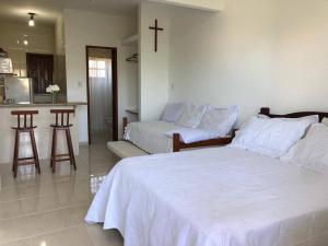 ein Schlafzimmer mit 2 Betten und einem Kreuz an der Wand in der Unterkunft Lofts Dois Corações in Cabo Frio + 43 Fotos