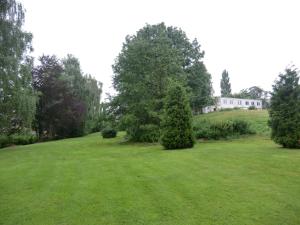 un gran campo de césped con una casa en el fondo en Hotel Oymanns, en Hamberge