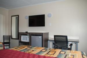 a bedroom with a bed and a flat screen tv at Inn of Lenoir Motor Lodge in Lenoir City