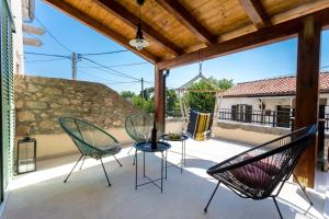 taras z krzesłami i stołem oraz kamiennym murem w obiekcie Holiday house DREAM w mieście Milohnići