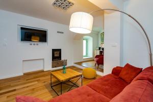 salon z czerwoną kanapą i stołem w obiekcie Holiday house DREAM w mieście Milohnići