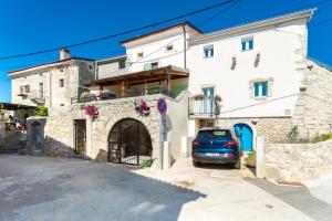 budynek z zaparkowanym przed nim samochodem w obiekcie Holiday house DREAM w mieście Milohnići