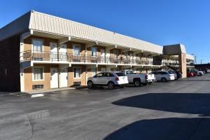 a large building with cars parked in a parking lot at Inn of Lenoir Motor Lodge in Lenoir City