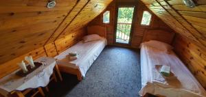 a room with two beds in a wooden cabin at Pensiunea Neba in Bran