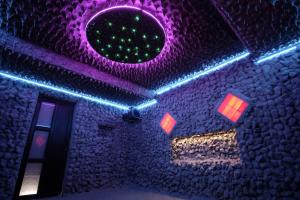 a room with purple and blue lights on the ceiling at Rai pe Vale Boutique & Spa in Leordina