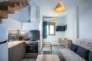 a kitchen and a living room with a couch at royal nest in Matala