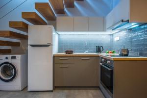 a kitchen with a refrigerator and a washing machine at royal nest in Matala