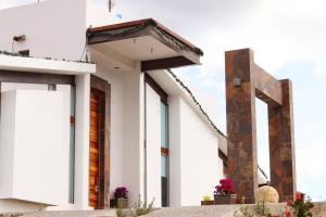 a white building with a cross on the side at San Antonio Hotel Boutique in Santiago Matatlán