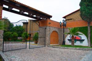 um portão para uma casa com uma palmeira em Hotel Sol y Fiesta em Tequisquiapan