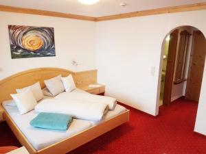 ein Schlafzimmer mit einem Bett mit weißen Kissen und einem Gemälde in der Unterkunft Gästehaus Dorfbäckerei in Tux