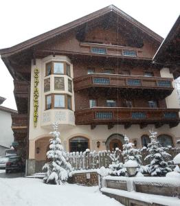 un edificio cubierto de nieve con una valla delante en Gästehaus Dorfbäckerei en Tux