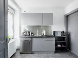 uma cozinha com armários brancos e um lavatório em Comfort Stay Basel Airport 2A46 em Saint-Louis
