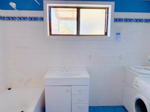biała łazienka z umywalką, wanną i oknem w obiekcie Vandy's shack at Mount Dutton Bay - ideal for couples and small families w mieście Mount Dutton Bay West