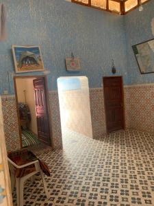 uma sala com um quarto com um espelho e uma porta em Guest House Imdoukal em Aït Tamellil